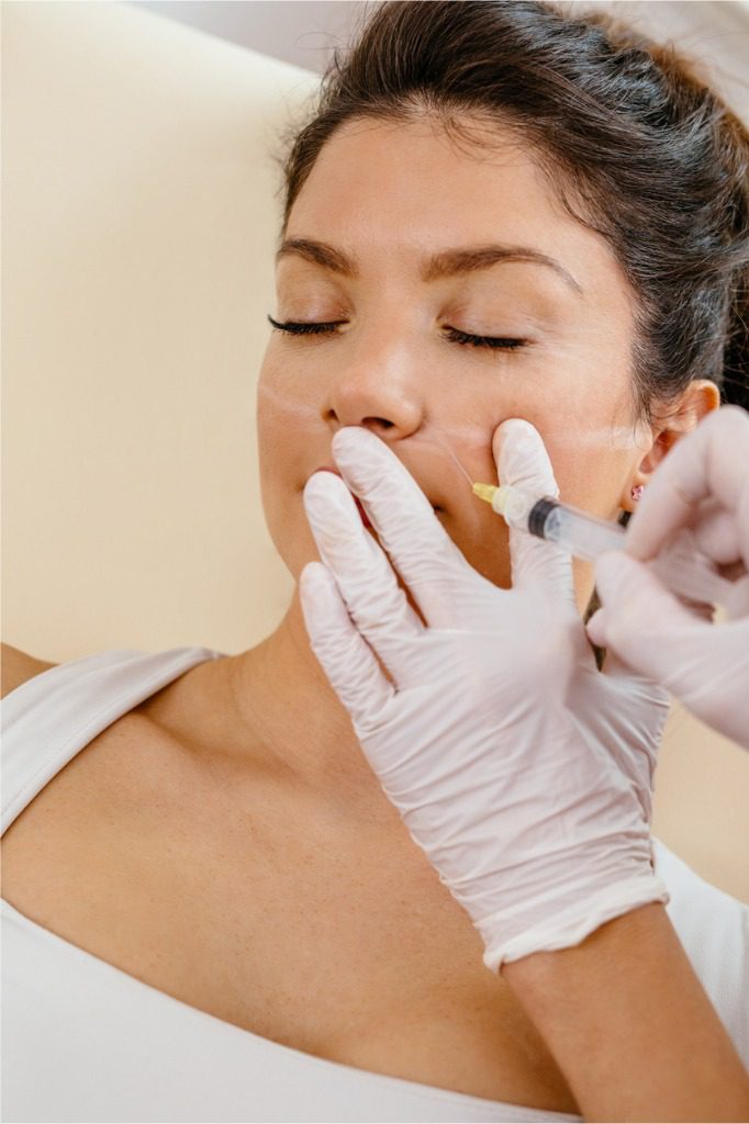 woman receiving facial injection of sculptra