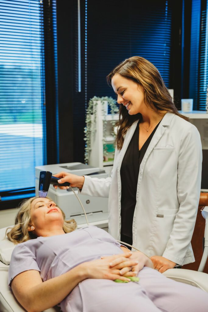 Aesthetician performing a non-invasive skincare treatment on a client at Reimagine Beauty Lancaster Med Spa.