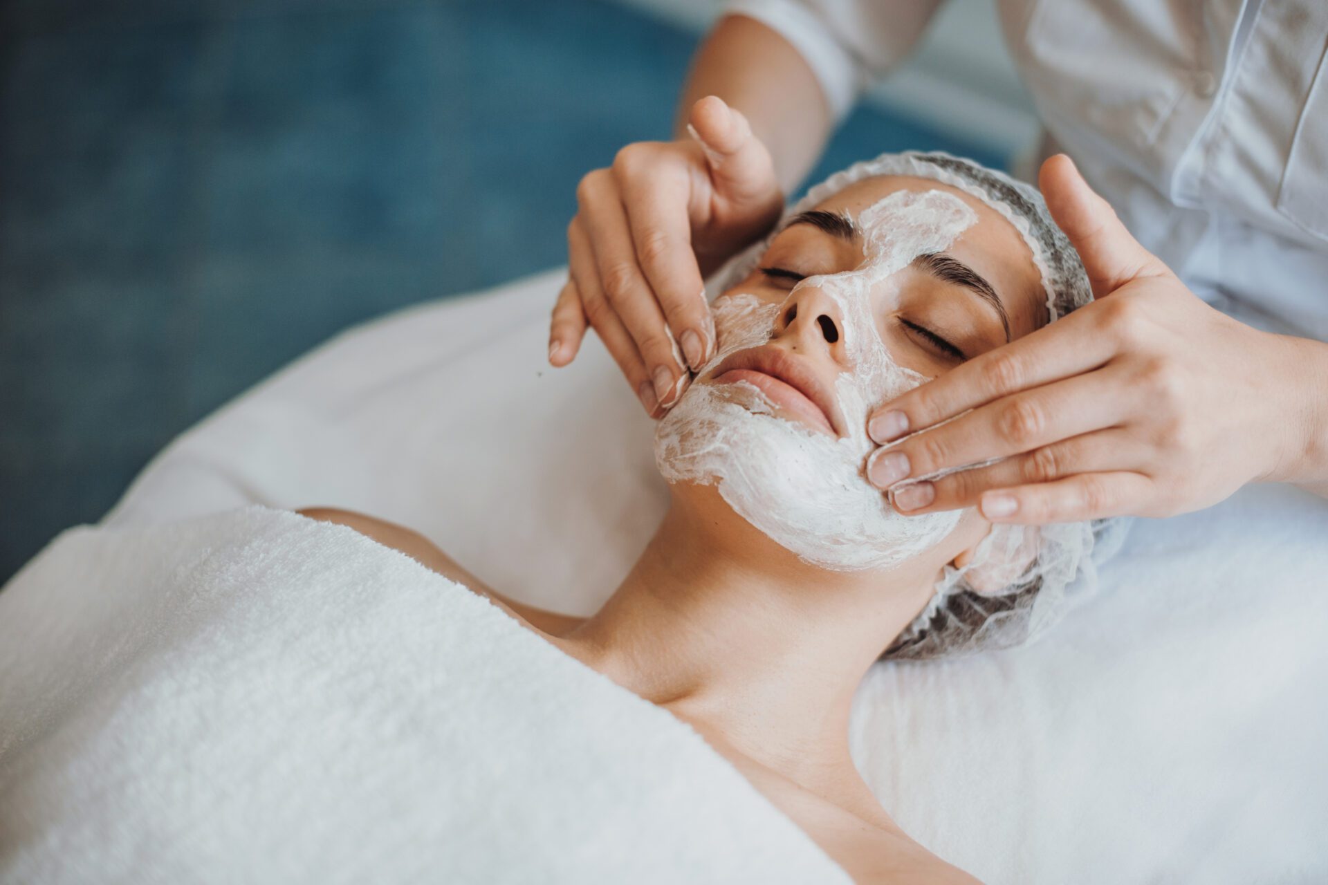 Cosmetologist doing hydrafacial treatment on woman face in beauty clinic