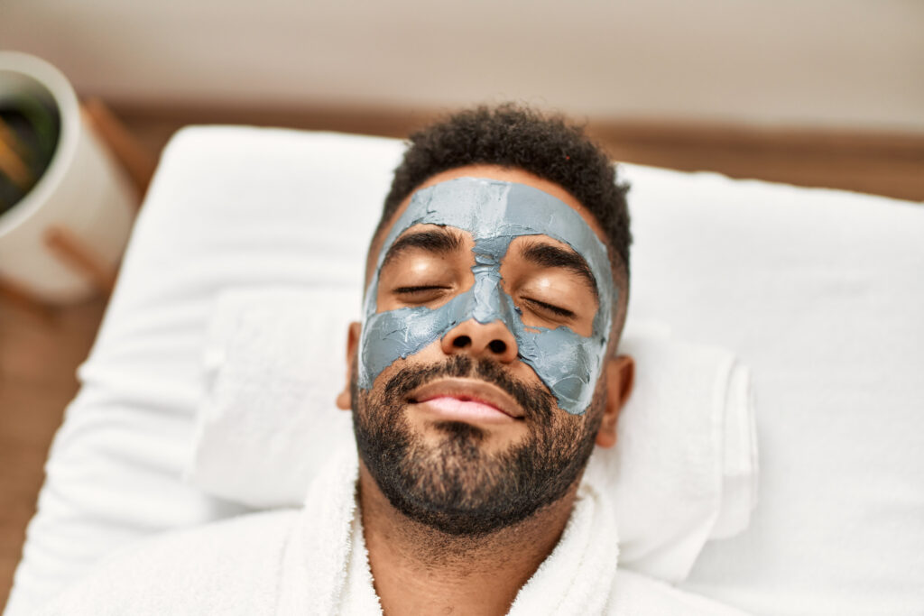 Man relaxed while receiving a facial treatment at Reimagine Beauty Lancaster Med Spa.