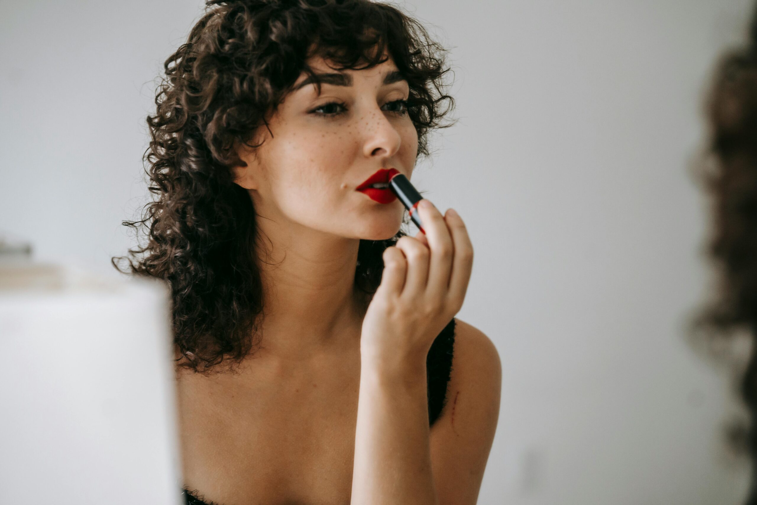 Beautiful women putting on lip stick. Showing her perfect pout depicting lip filler and lip flip treatments.