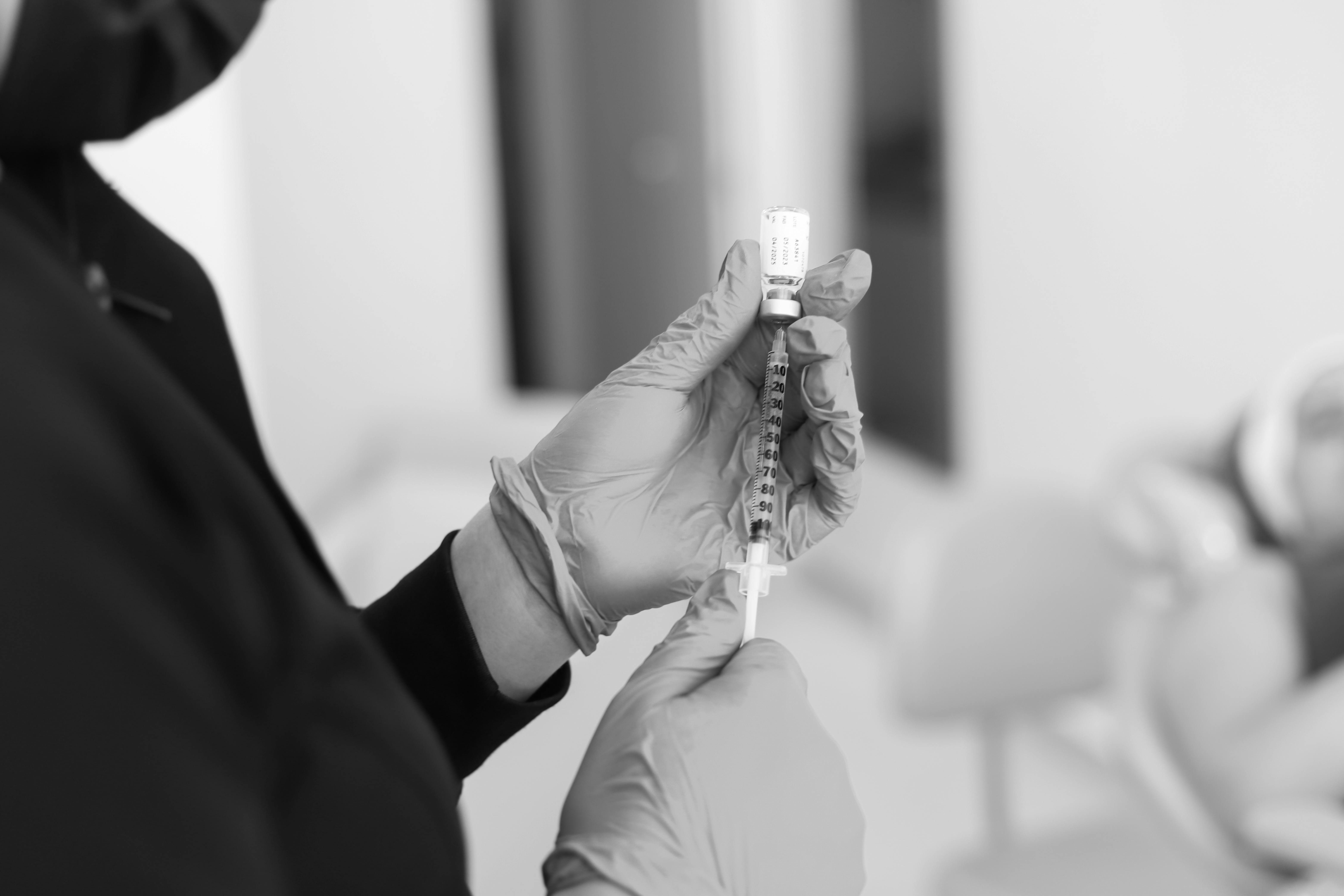 Women holding a syringe and botox bottle