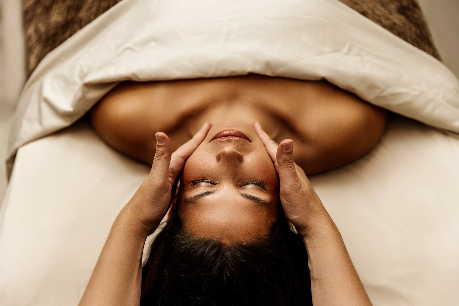 Client receiving a facial treatment from a Reimagine Beauty esthetician.
